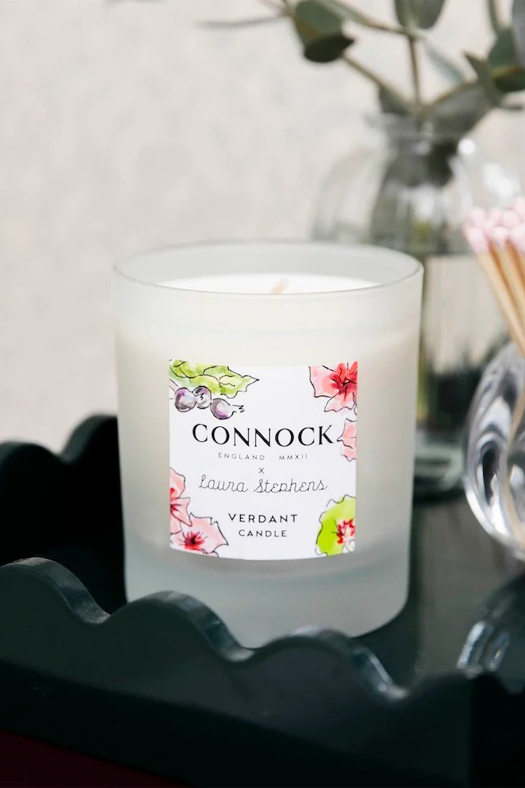 Connock candle with floral label on a dark surface