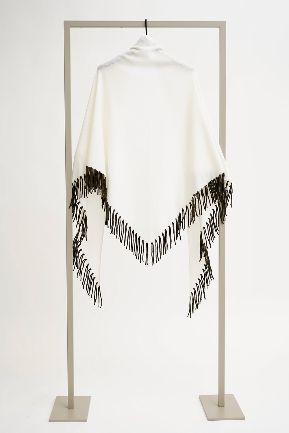 White turtleneck with black fringe on a mannequin against a white background