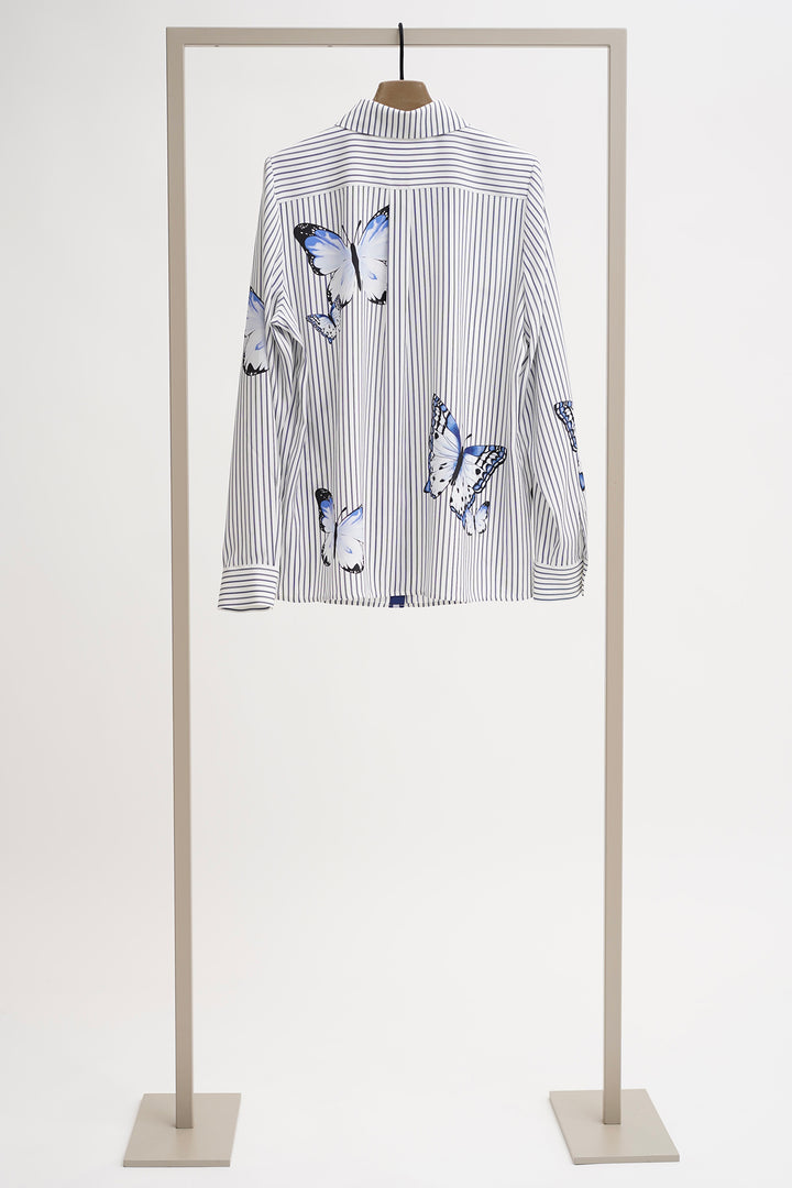 Striped shirt with butterfly designs on a mannequin against a white background