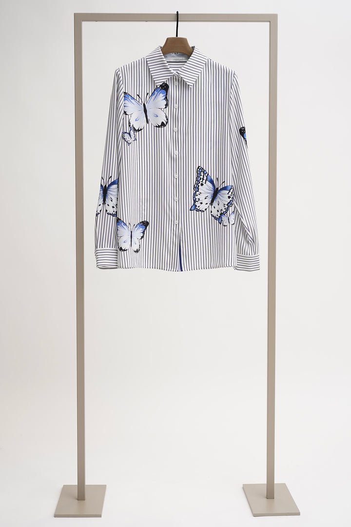 Striped shirt with butterfly designs on a mannequin against a white background