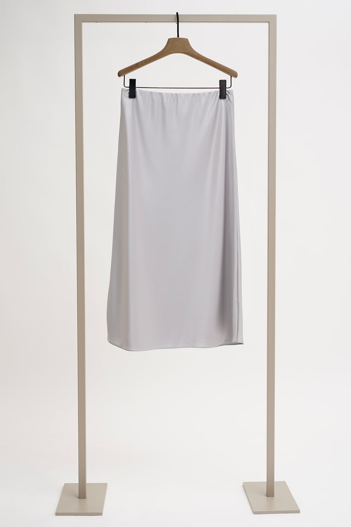 White skirt on a hanger against a white background