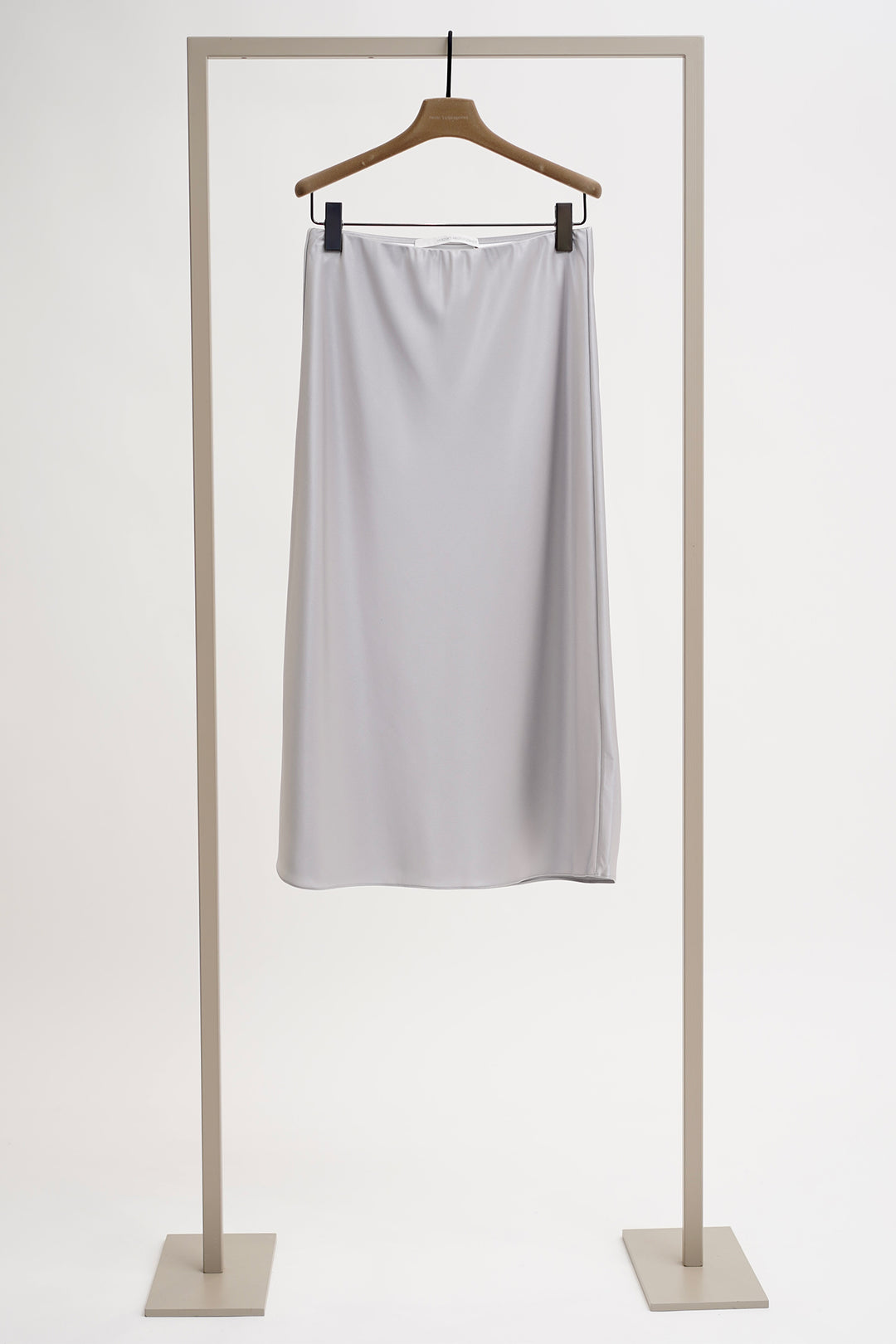 Light gray skirt on a hanger against a white background