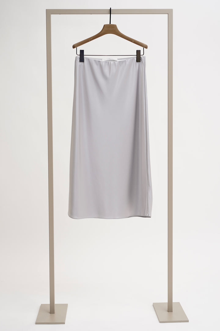 Light gray skirt on a hanger against a white background