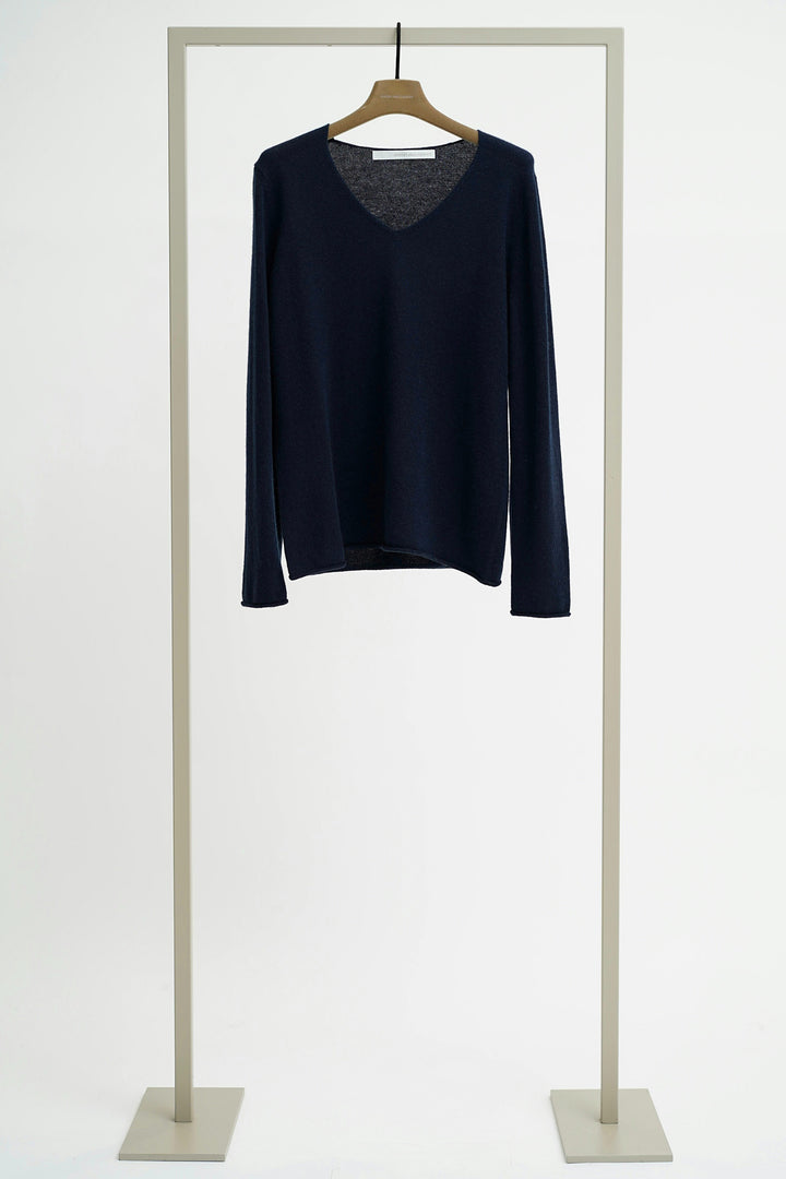 Navy blue sweater on a hanger against a white background