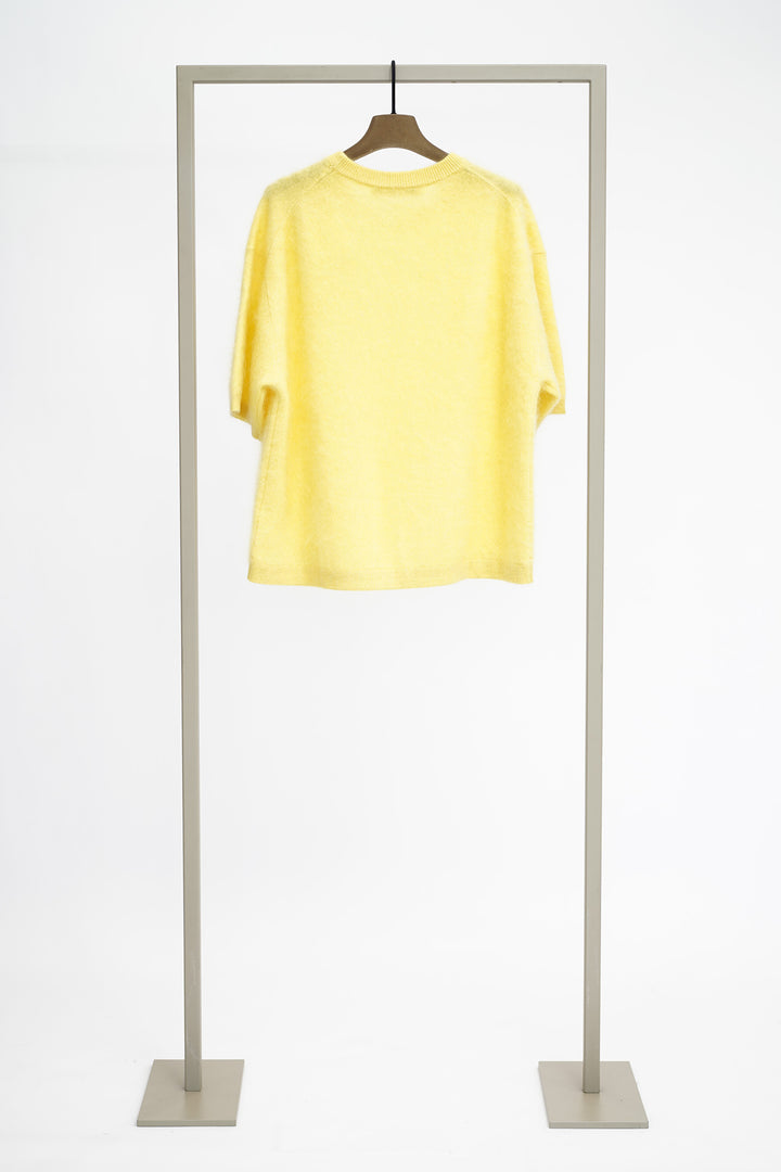 Yellow jumper from back on a hanger against a white background