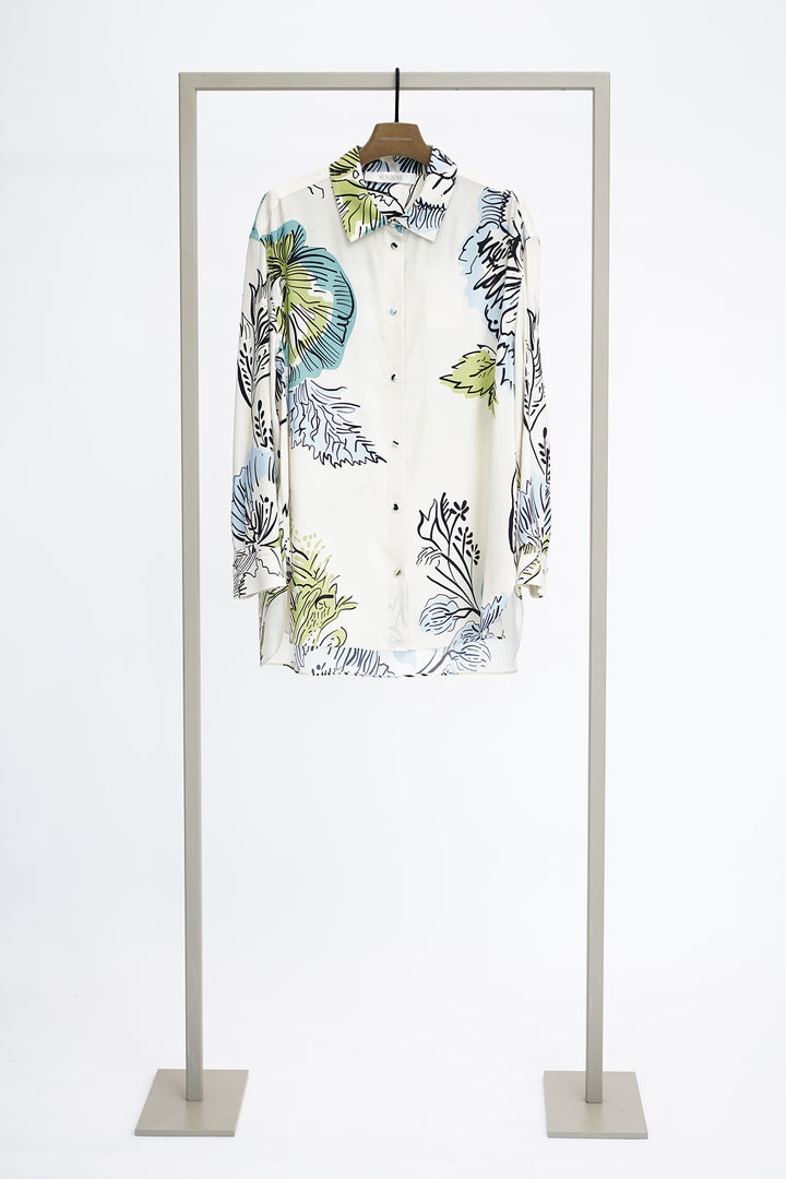 Shirt with large floral pattern on a hanger against a white background