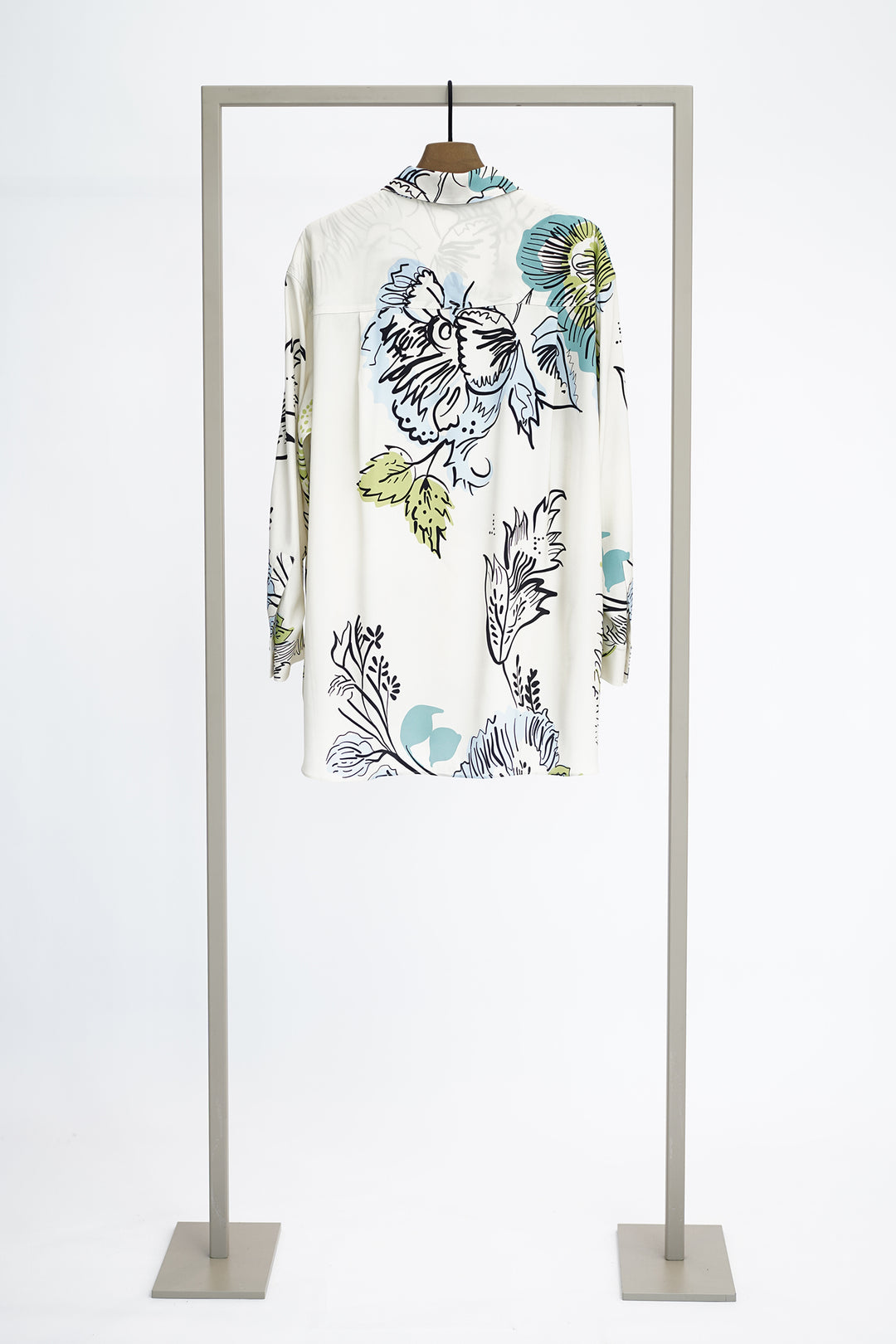 Shirt with large floral pattern to show back on a hanger against a white background