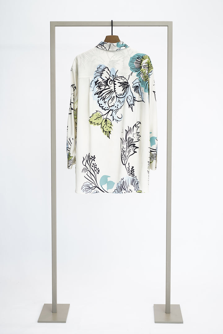 Shirt with large floral pattern to show back on a hanger against a white background