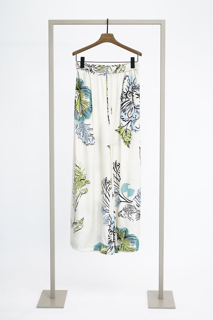 Large floral print trousers on a hanger against a white background