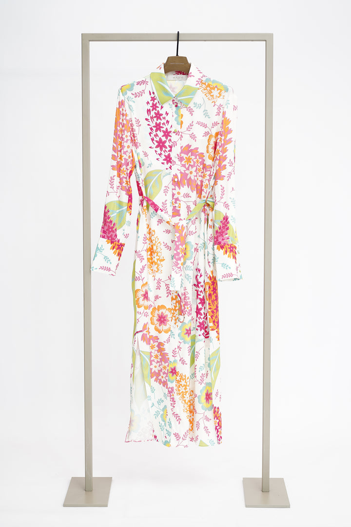 Pink and green print long dress on a hanger and frame against a white background