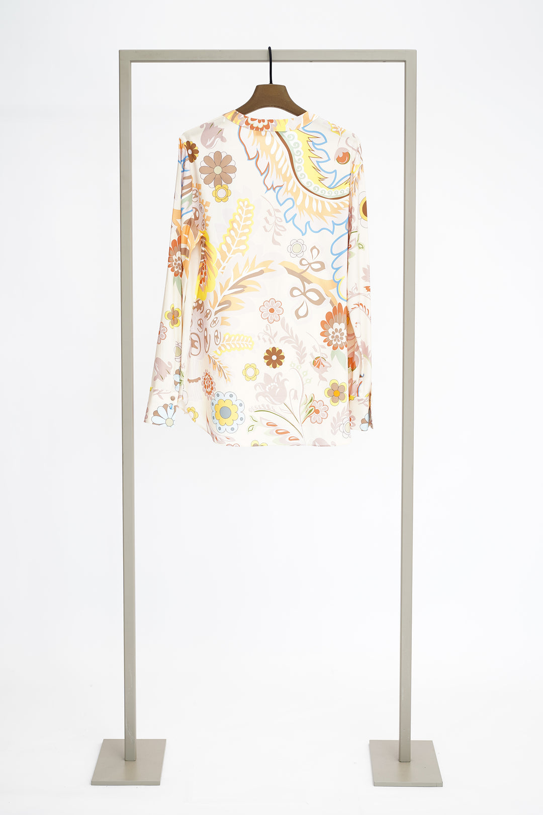 Colorful floral blouse to show back on a hanger against a white background