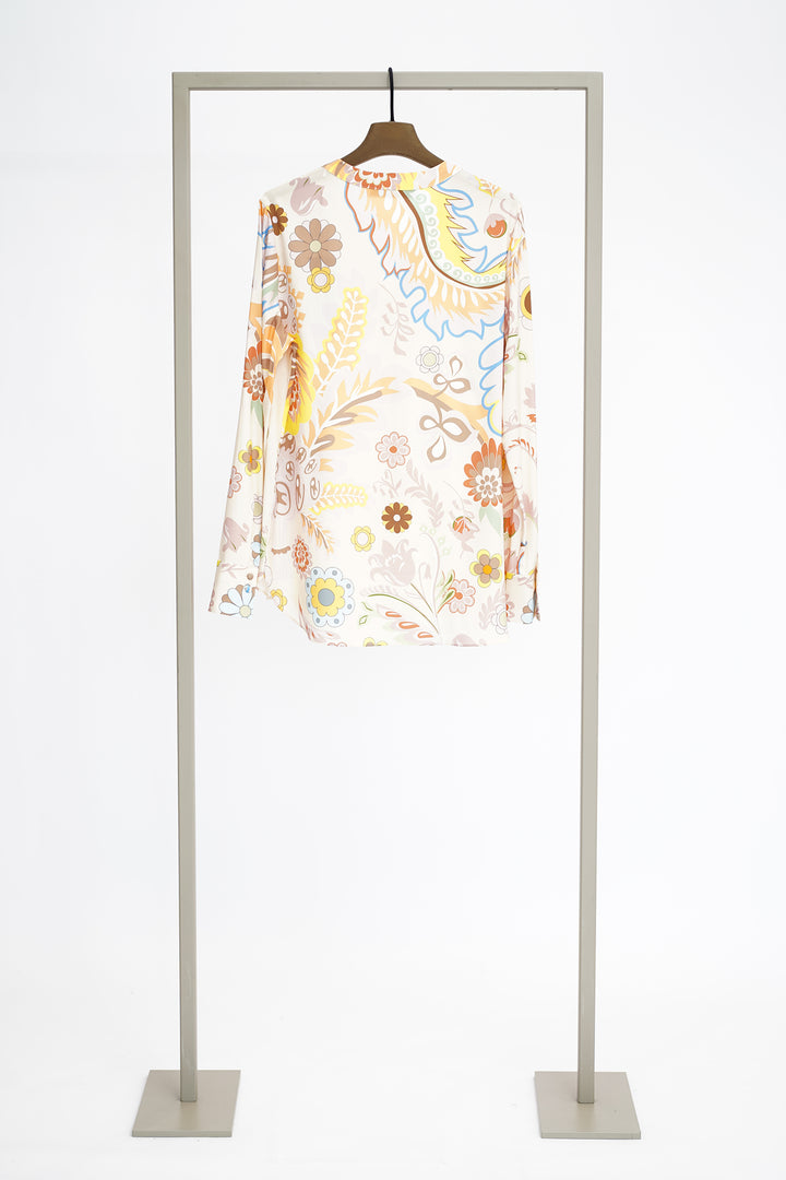 Colorful floral blouse to show back on a hanger against a white background