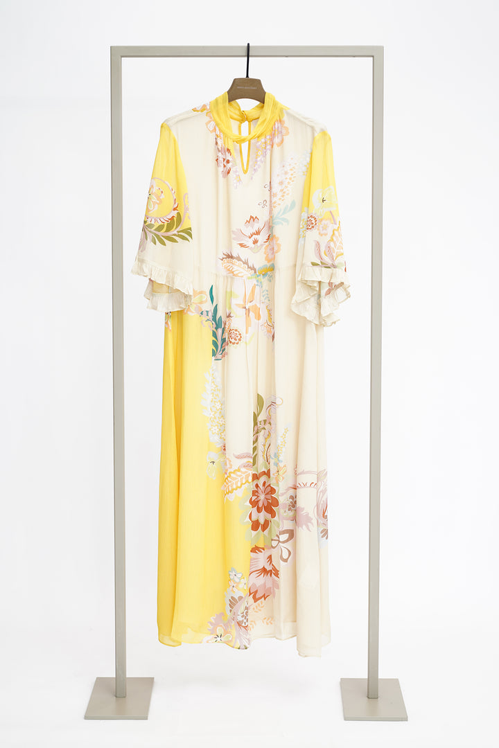Yellow and floral print dress on a hanger against a white background