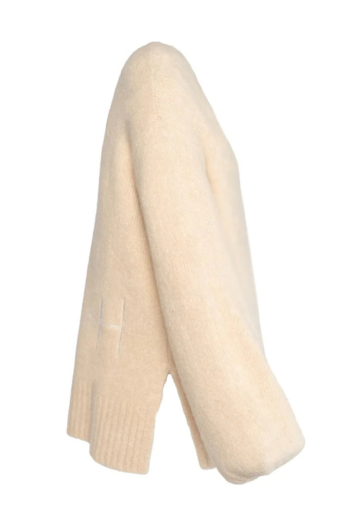 Folded cream-colored sweater on a white background