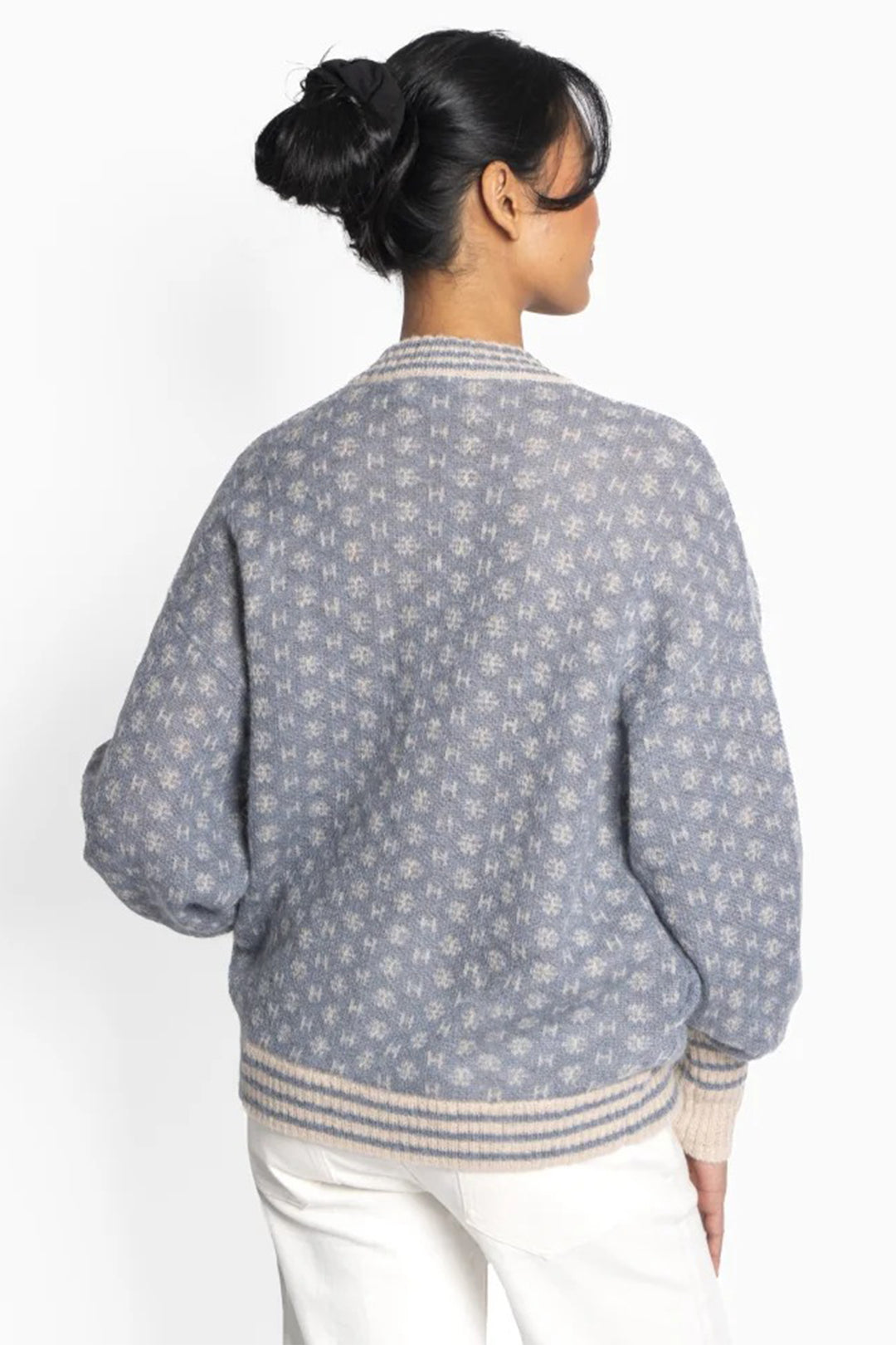 Woman wearing a patterned gray sweater on a white background