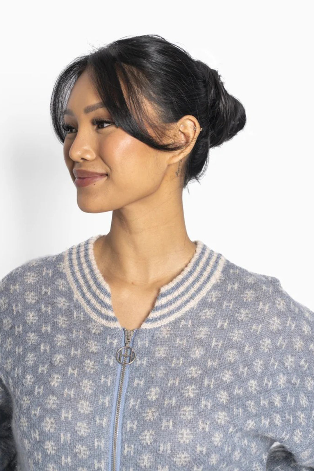 Woman wearing a patterned sweater against a white background