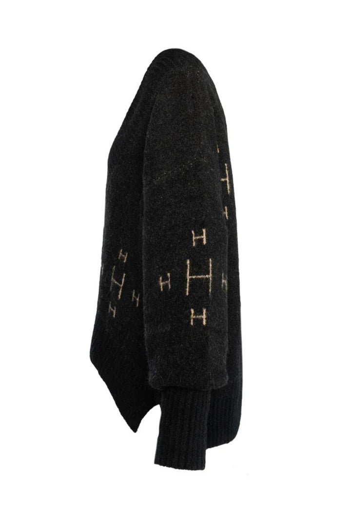 Black jumper with gold patterns on a white background