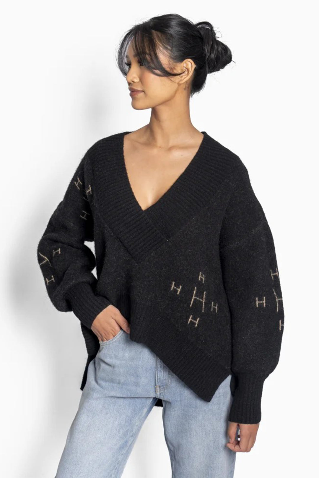 Woman wearing a black sweater with geometric patterns on a white background