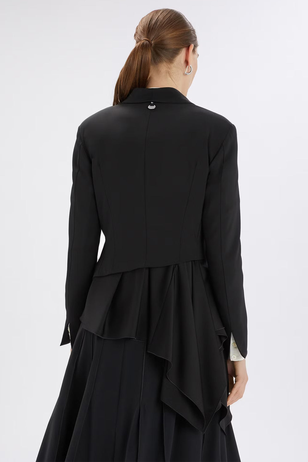 Black jacket with a layered skirt worn by a person on a white background