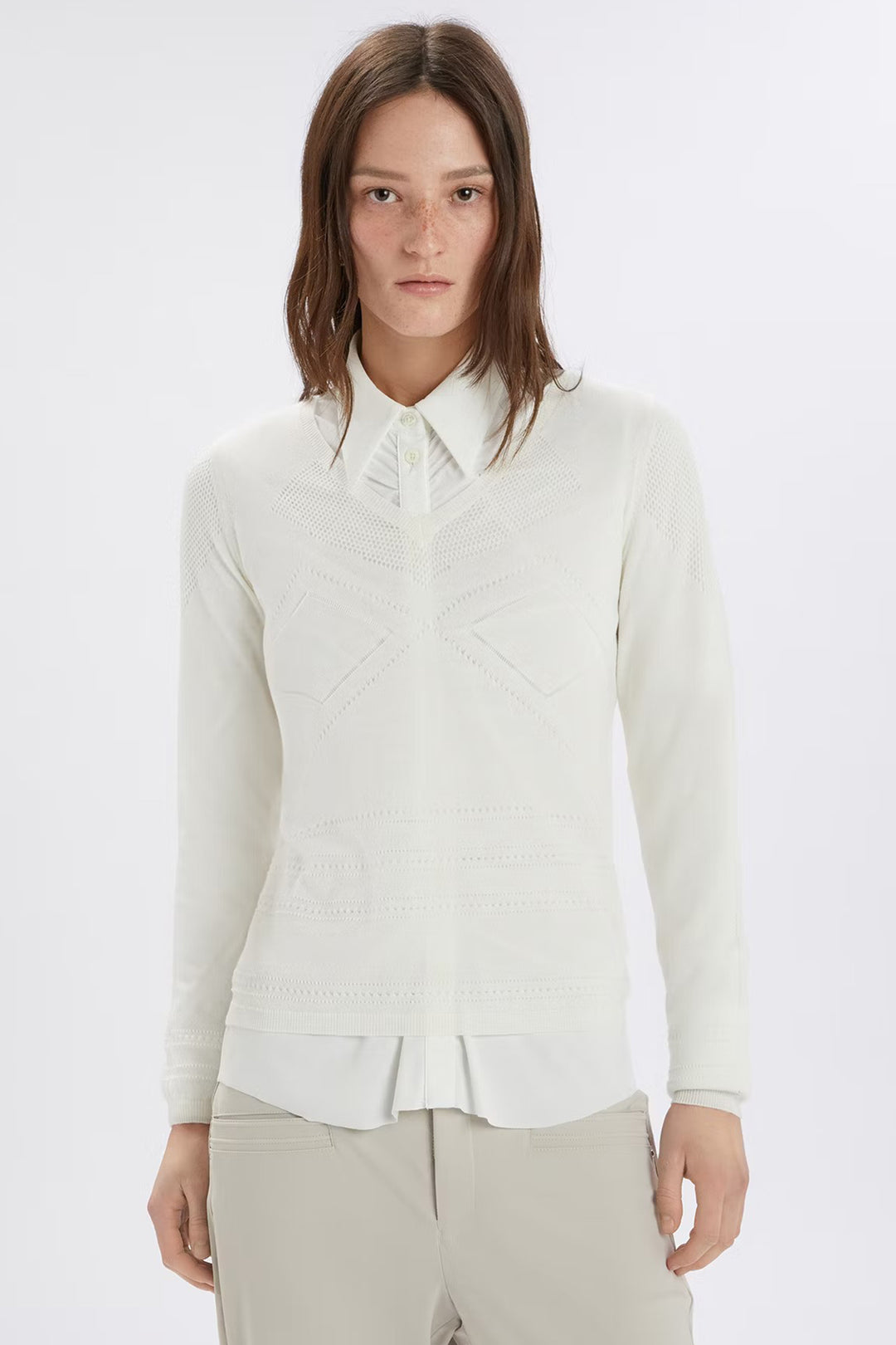 Woman wearing a white blouse with a ruffled collar on a white background