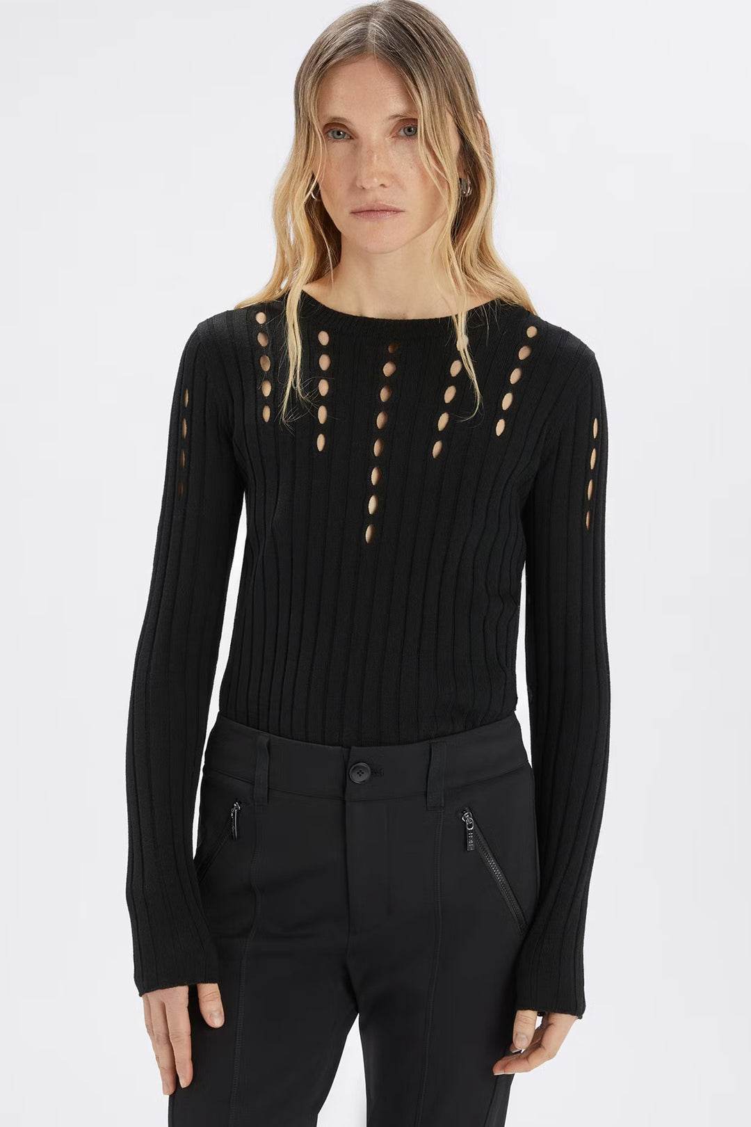 Woman wearing a black long-sleeve top with cut-out details on a white background