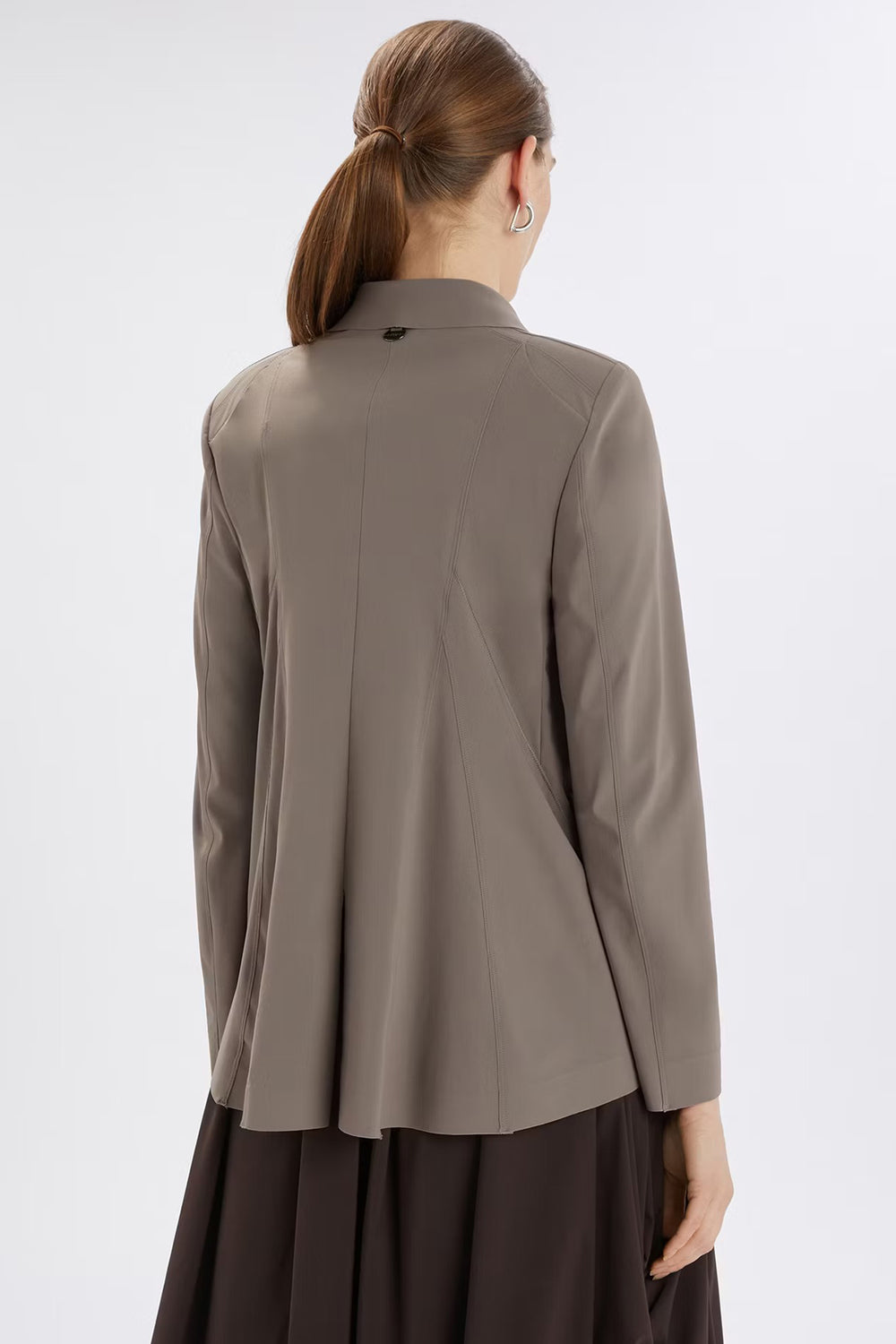Person wearing a beige long-sleeve top on a white background