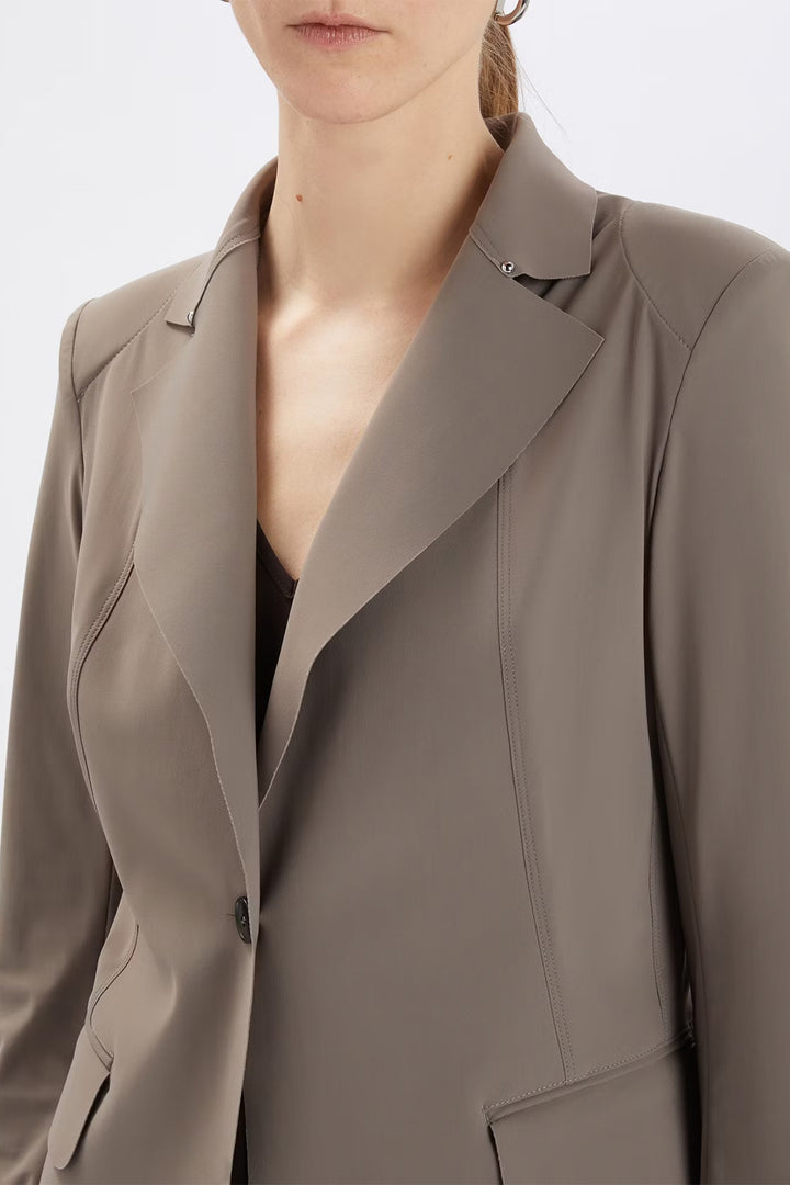 Close-up of a person wearing a beige blazer on a white background