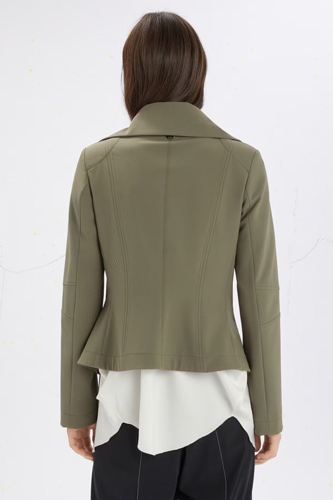 Person wearing a green jacket over a white top on a white background
