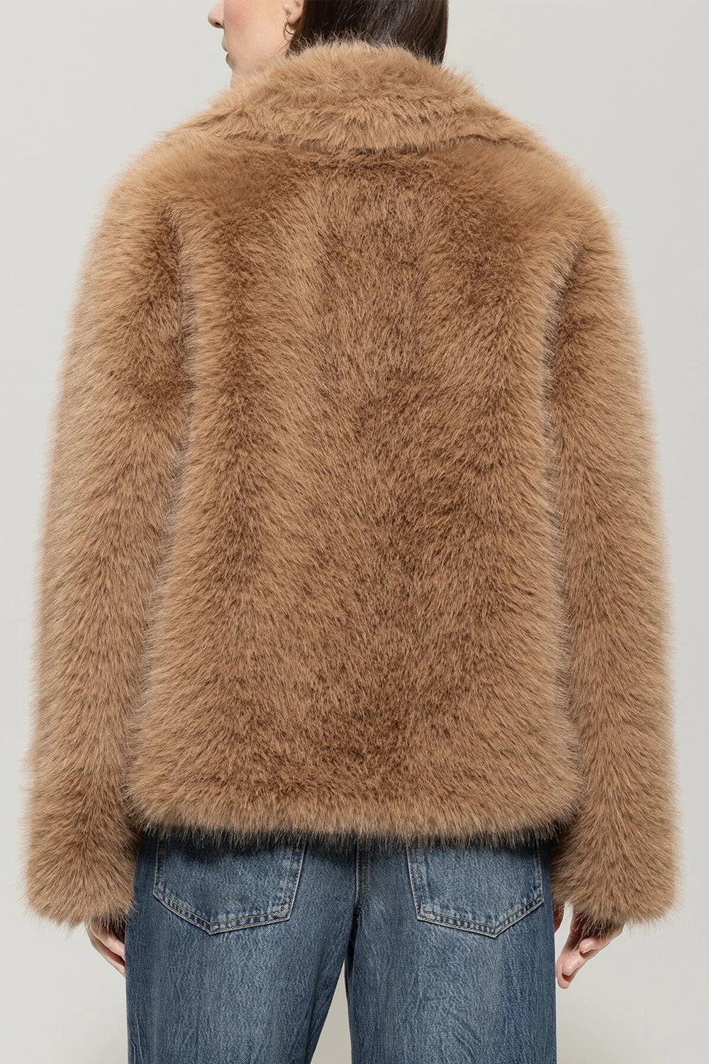 Brown fluffy jacket worn by a person on a plain background