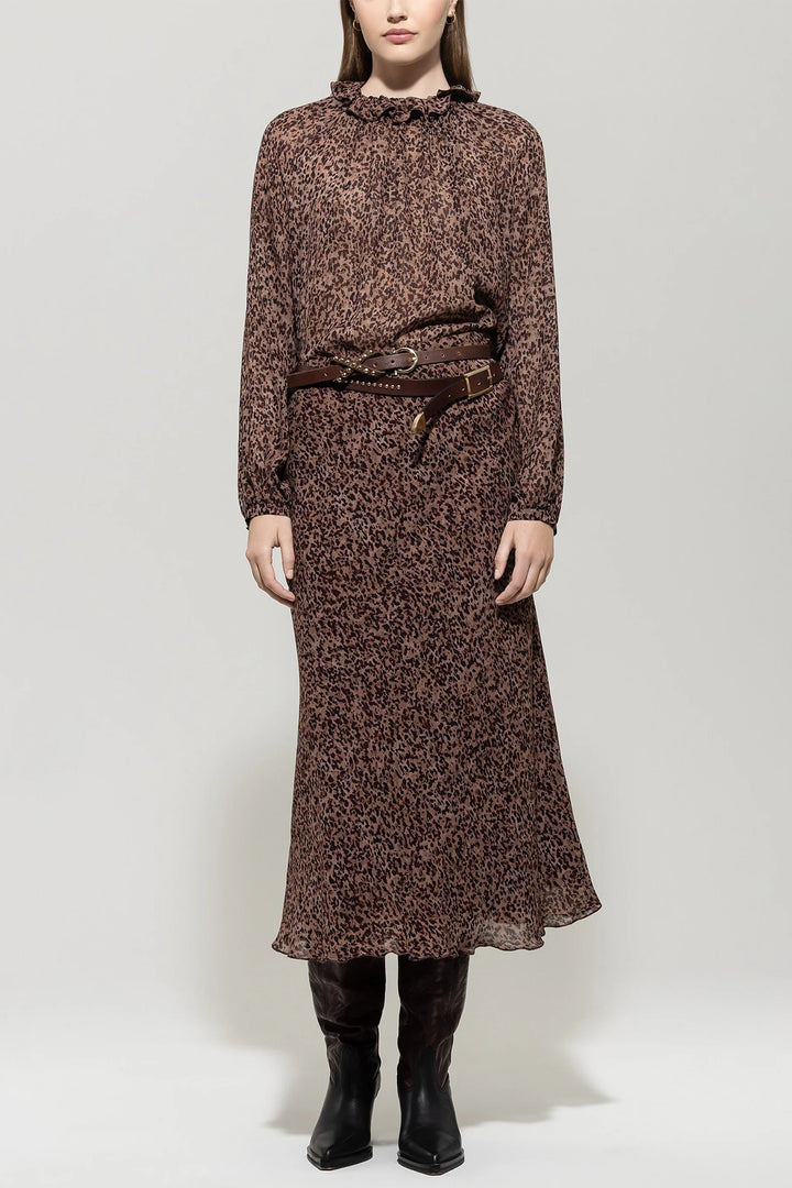 Woman wearing a brown patterned dress with a belt on a white background