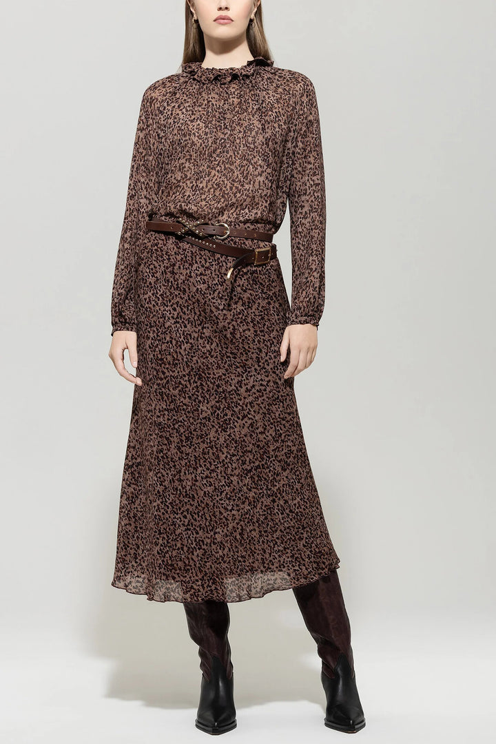 Woman wearing a brown patterned dress with a belt on a white background
