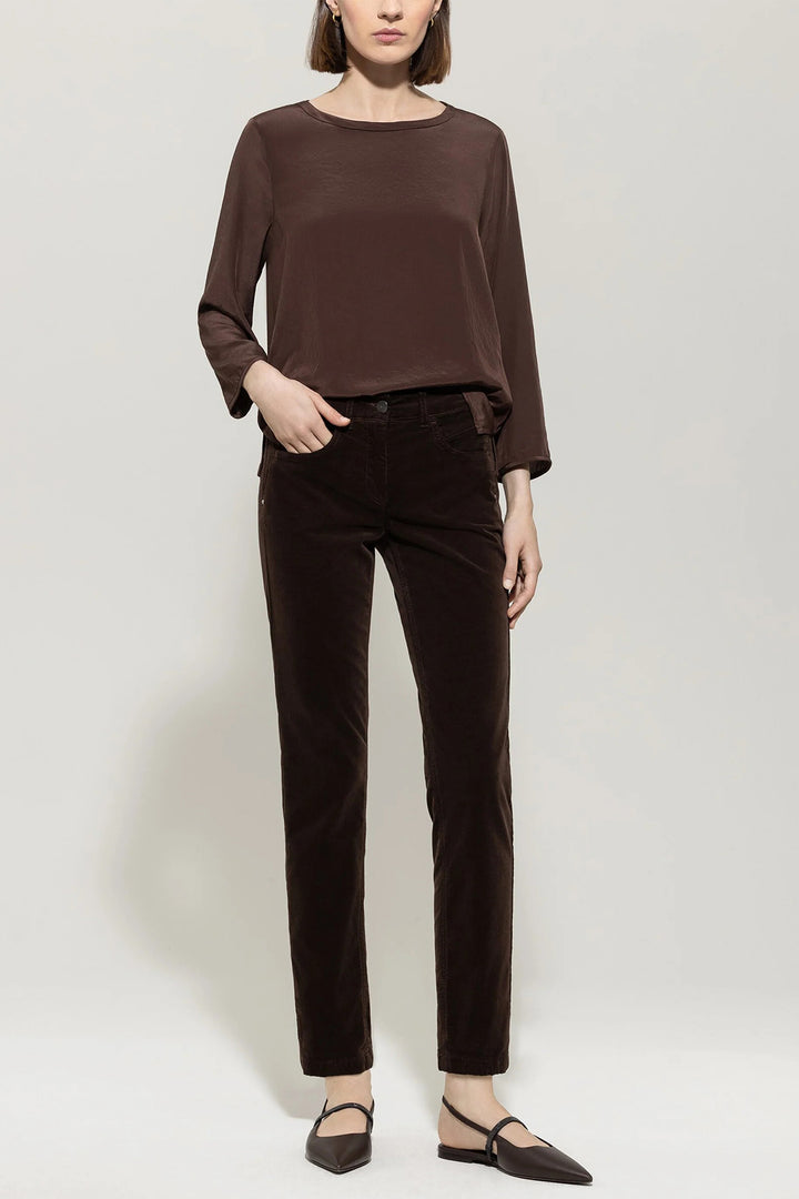Person wearing a brown top and pants on a white background