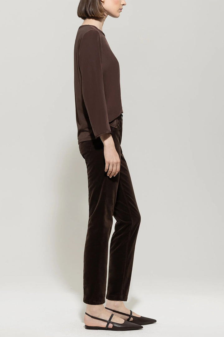 Person wearing a brown outfit standing against a white background
