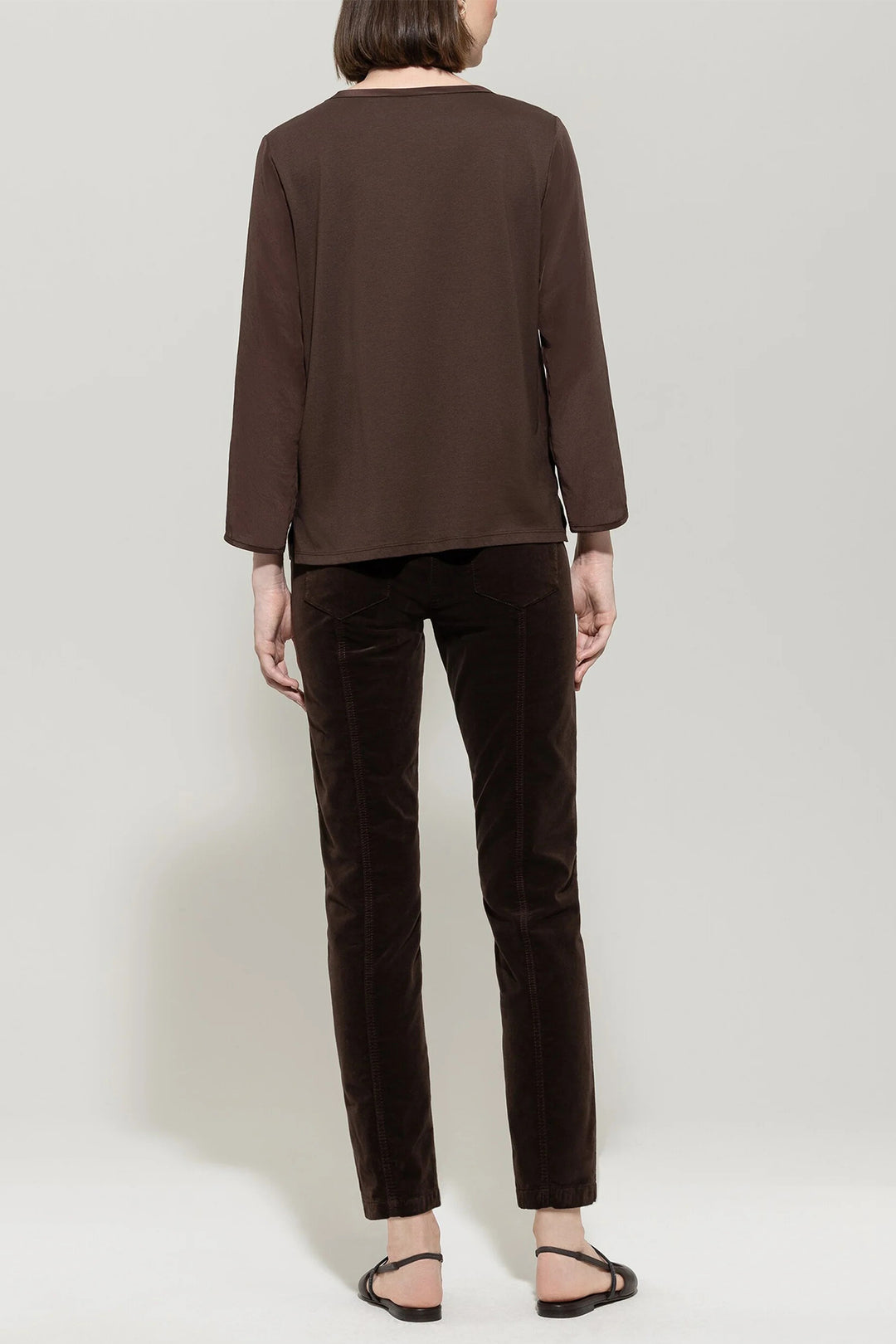 Person wearing a brown outfit on a plain background