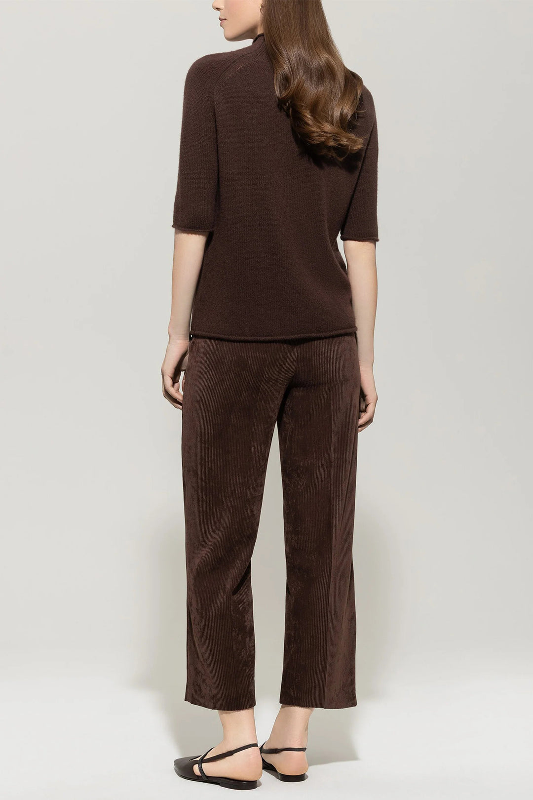 Woman wearing a brown outfit with a plain background
