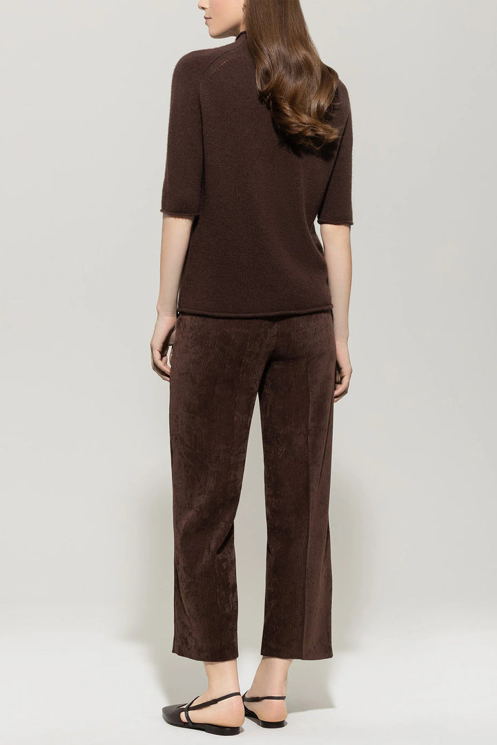 Woman wearing a brown outfit with a plain background