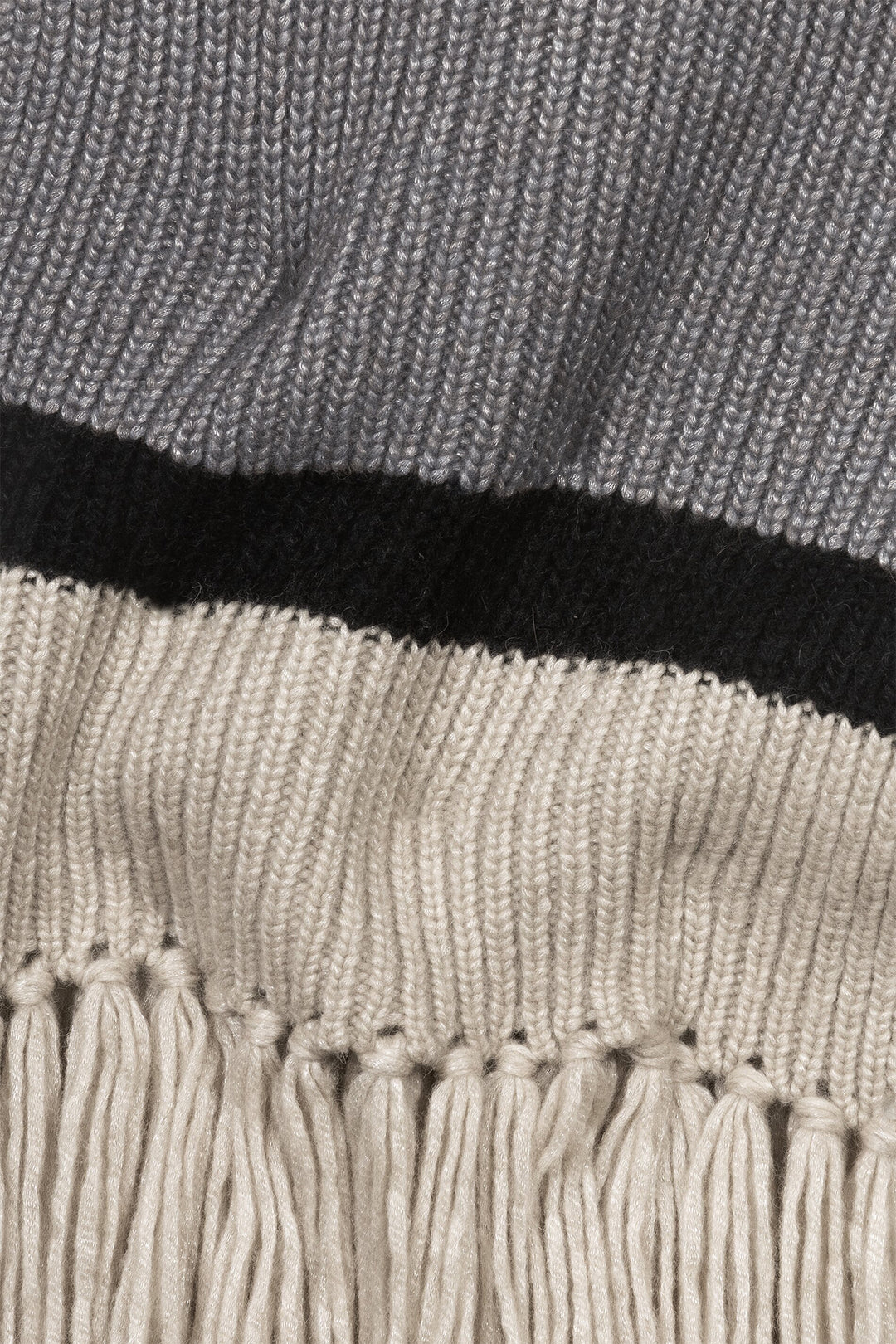 Close-up of a textured fabric with fringes, featuring gray, black, and beige colors.