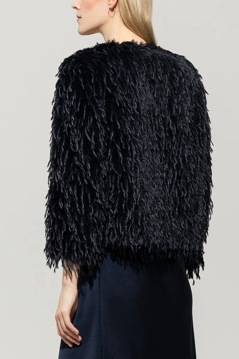 Navy shaggy jacket worn by a person on a plain background
