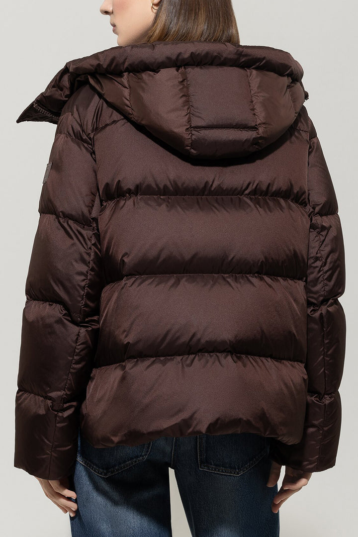 Brown puffer jacket worn by a person on a plain background