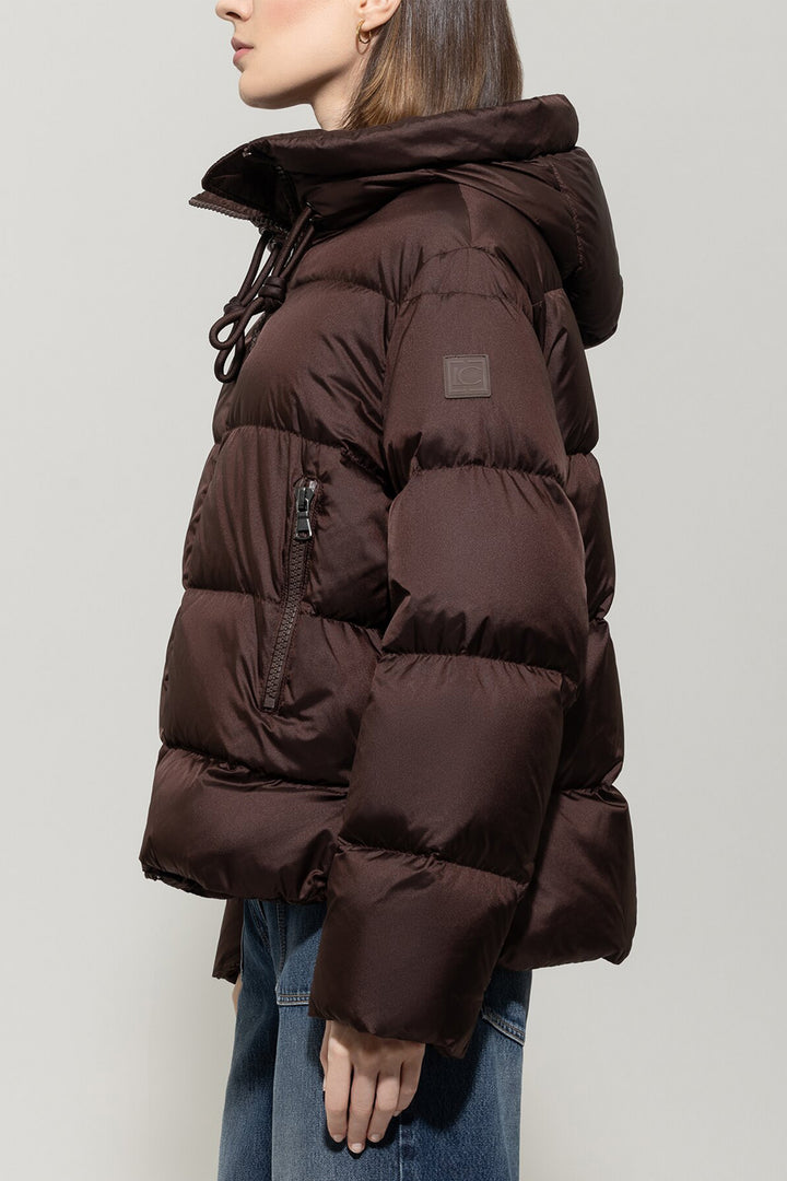 Brown puffer jacket worn by a person on a light gray background