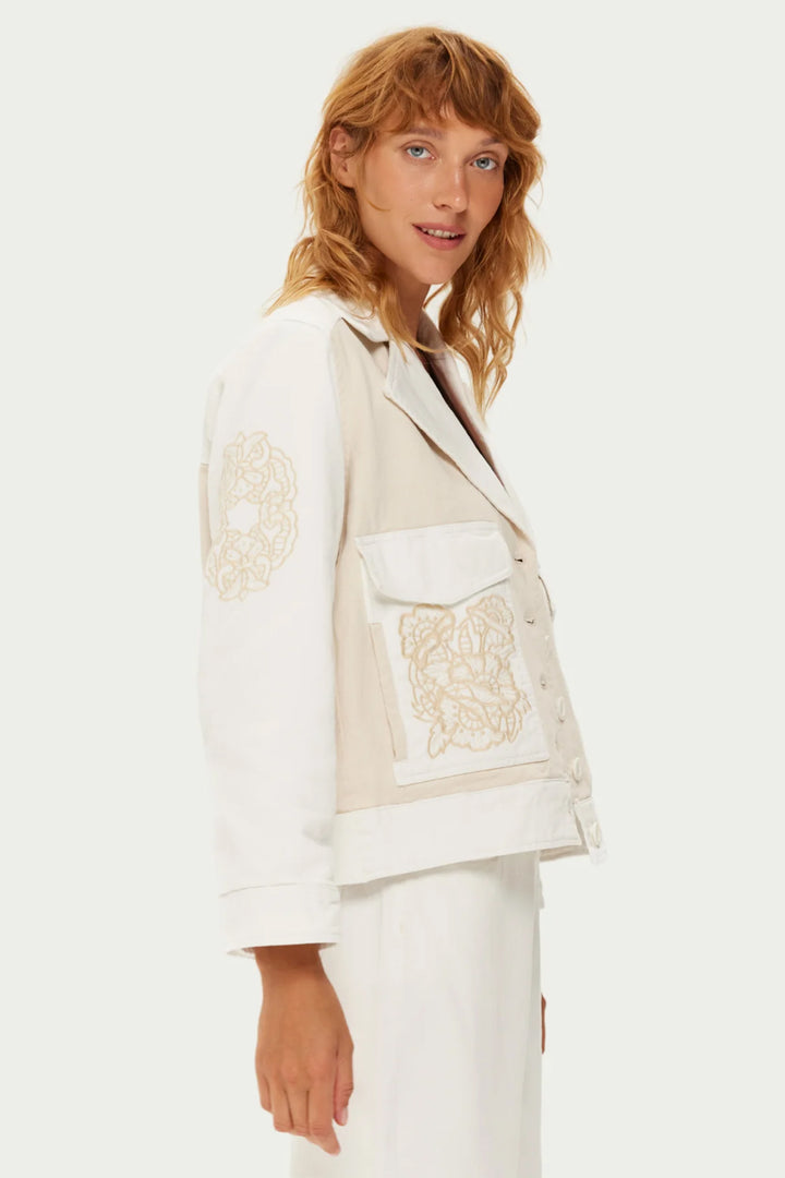Woman wearing a white jacket with lace details on a white background