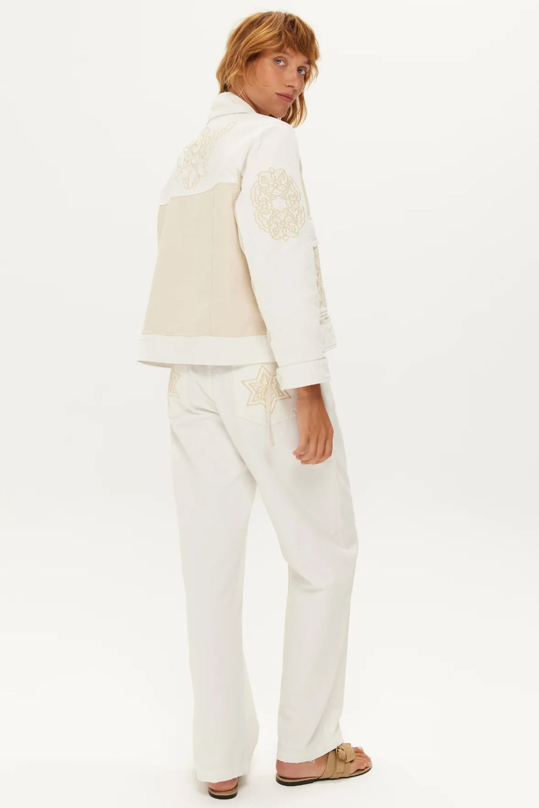 Woman wearing a cream-colored outfit with a white background
