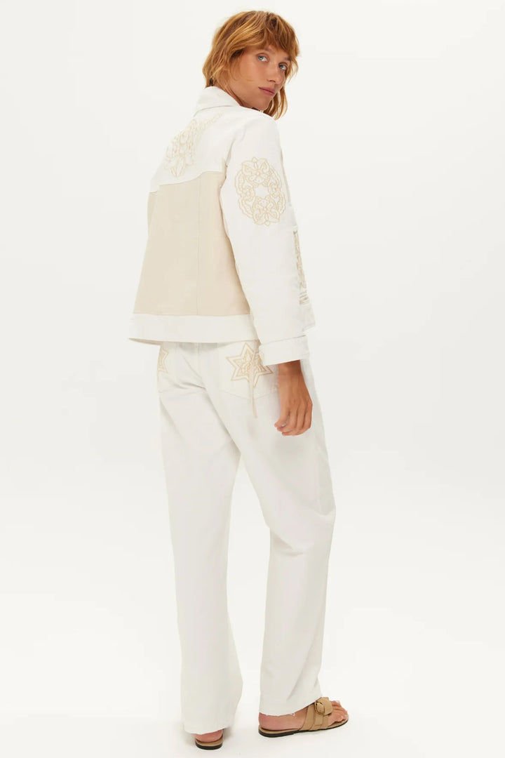 Woman wearing a cream-colored outfit with a white background