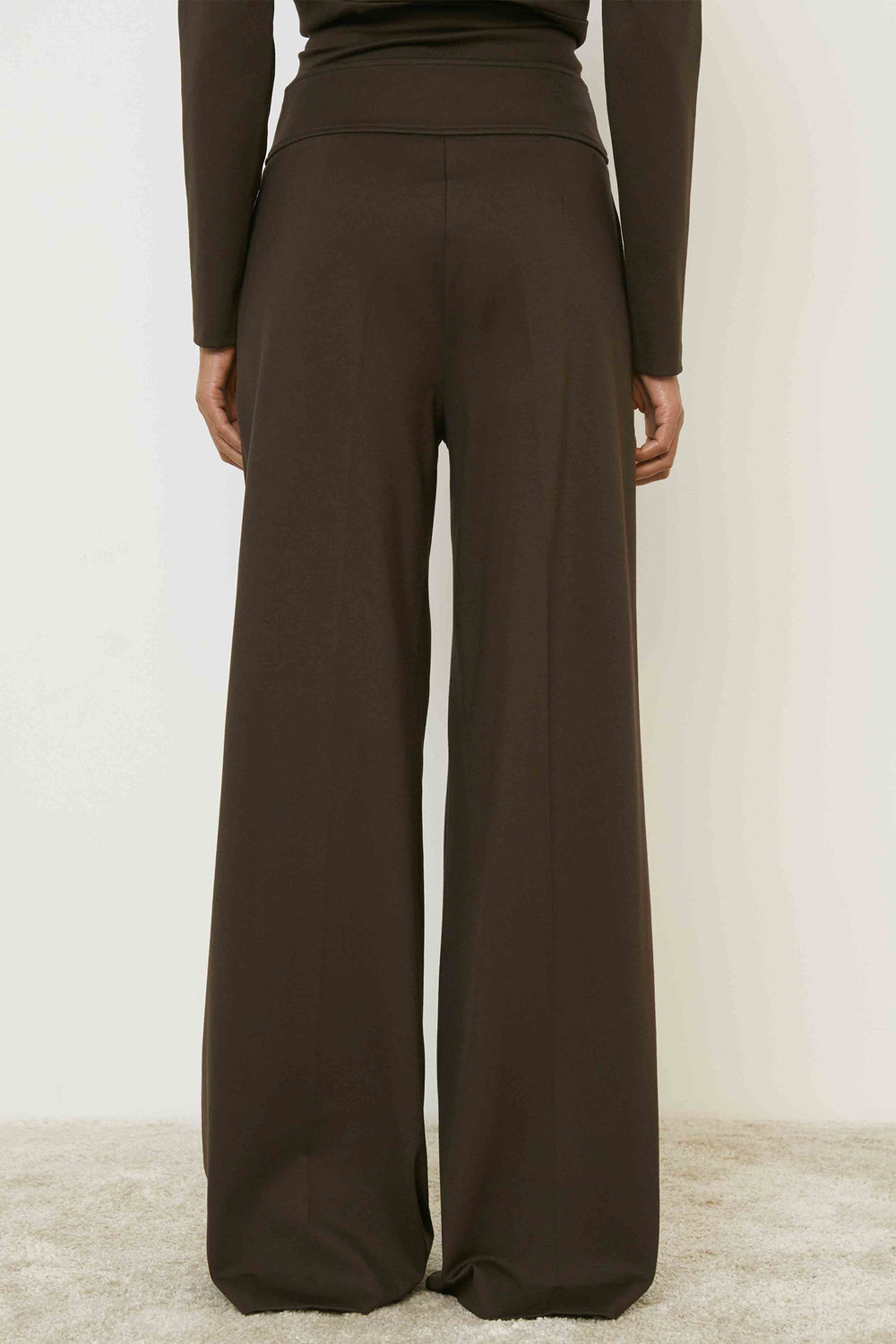 Brown wide-leg pants worn by a person on a white background
