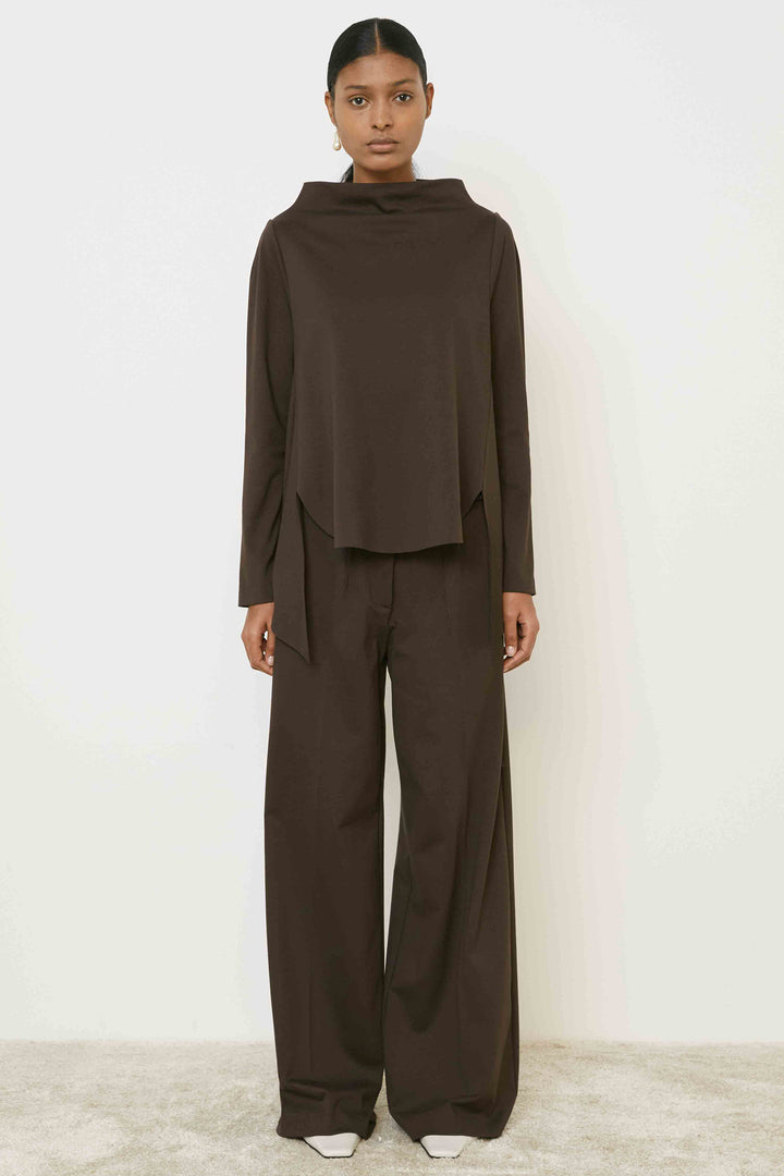 Person wearing a brown outfit on a white background
