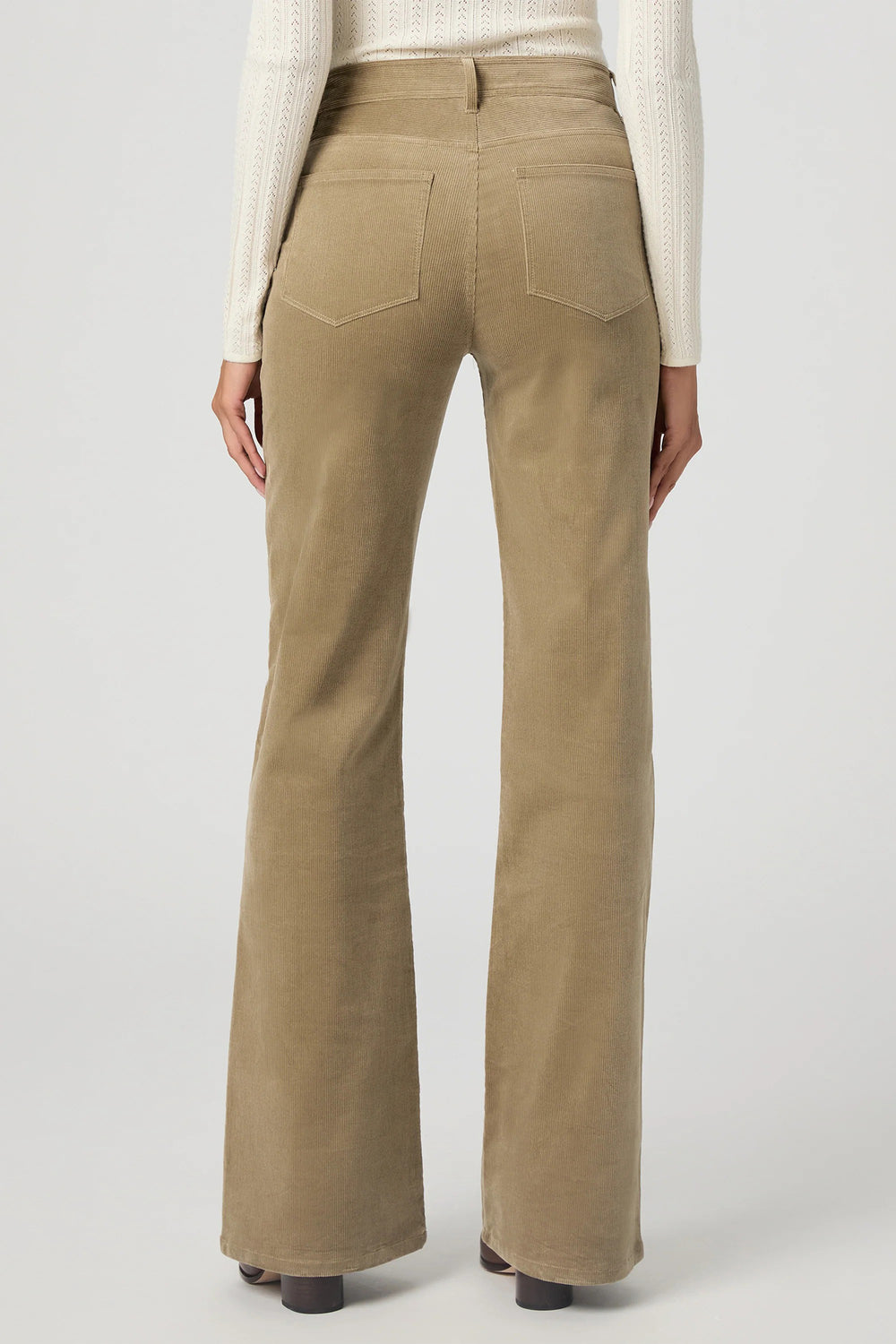 Beige flared pants worn by a person on a light gray background