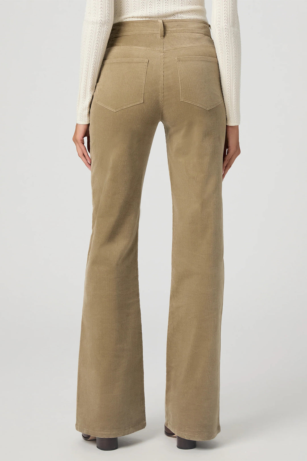 Beige flared pants worn by a person on a light gray background