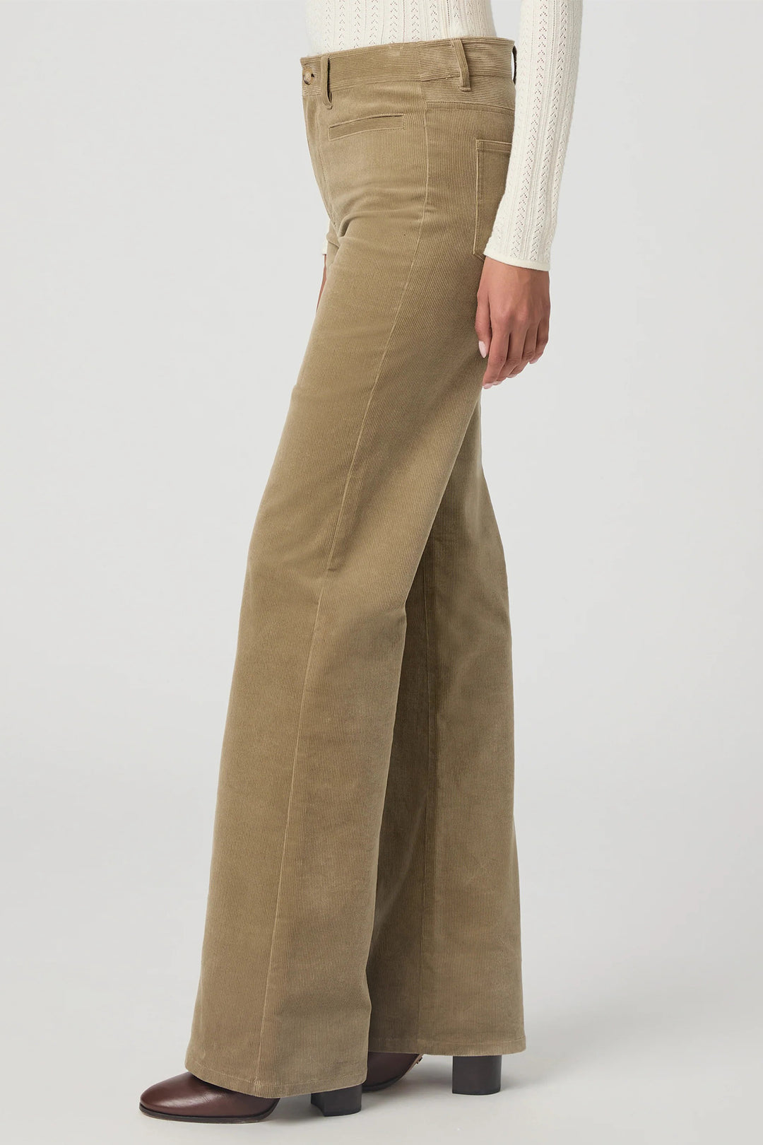 Khaki corduroy pants worn by a person on a white background