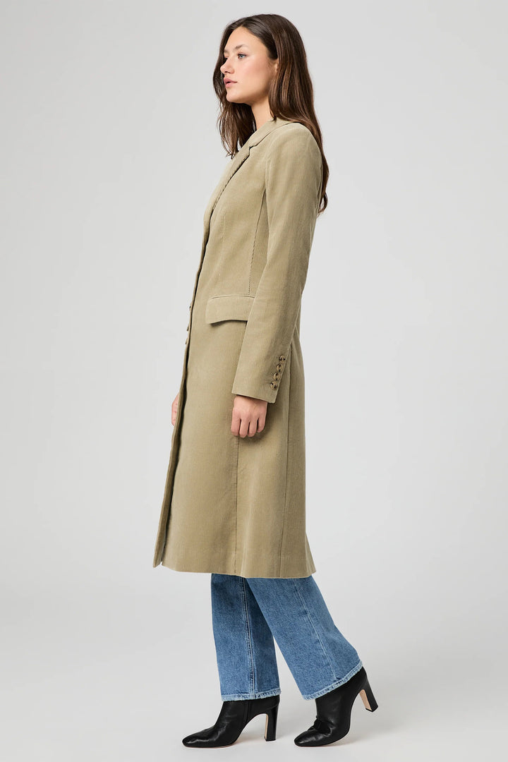 Woman wearing a long beige coat on a white background
