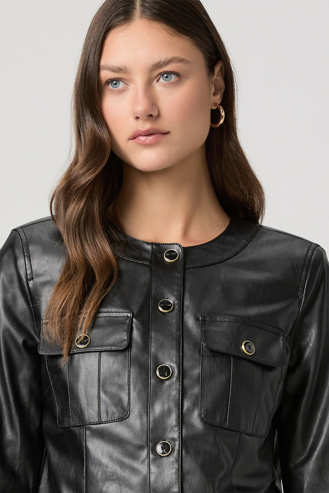 Woman wearing a black leather jacket with a plain background